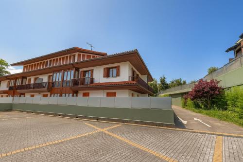 a building with a parking lot in front of it at Talaimendi Apartamentuak Zarautz in Zarautz