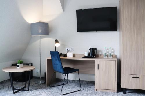 a hotel room with a desk and a tv on the wall at Hotel Polonia Centrum in Wrocław