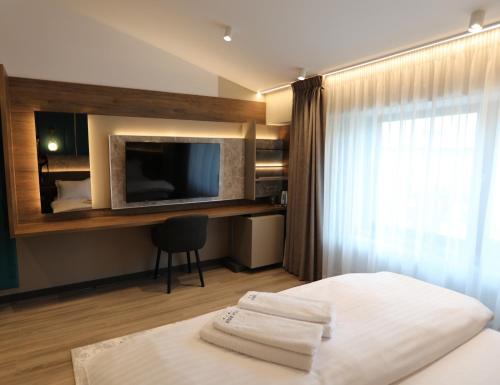 a hotel room with a bed and a television at Villa Bijoux in Ploieşti