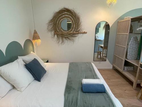 a bedroom with a large white bed with a mirror at Le lagon Bleu suite 5 étoiles in Les Issambres