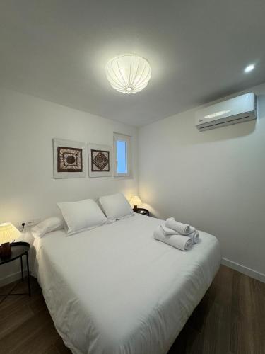 1 dormitorio con cama blanca grande y luz en Fórum Romano Tarragona, en Tarragona