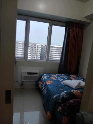 a bedroom with a bed and a large window at Home style Staycation in Manila