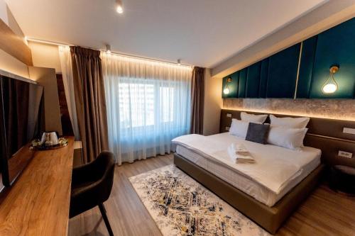 a hotel room with a bed and a television at Villa Bijoux in Ploieşti