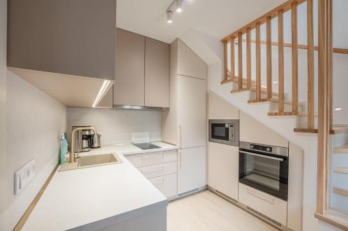 a kitchen with white cabinets and a staircase at Chata u Tichého Lesa Pernink in Pernink