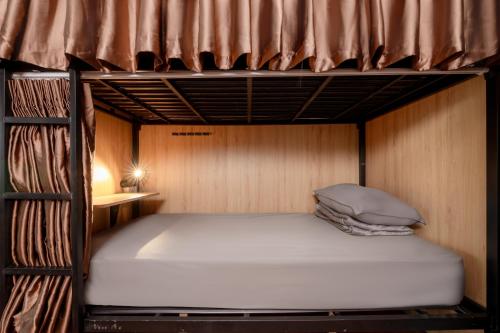 a bunk bed in a small room with a bed at The 93 in Ho Chi Minh City