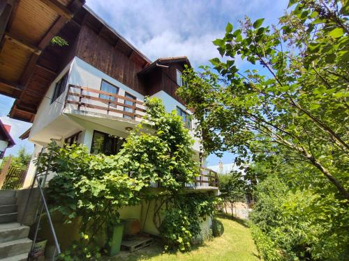 a house with a balcony on the side of it at Maison Bramber- a Home for those who seek it. in Predeluţ