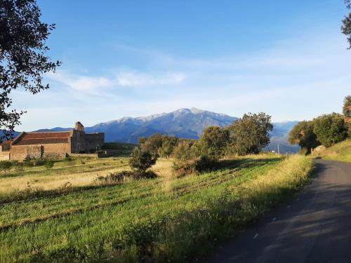 a road with a house and mountains in the background at Chez Louise in Arboussols