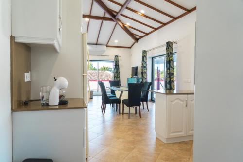 a kitchen and dining room with a table and chairs at Chalé d'Angra Guest House in Angra do Heroísmo