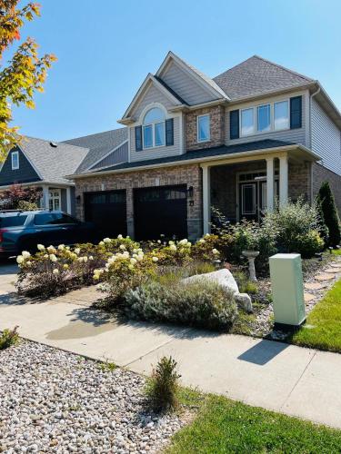 a house with a garden in front of a driveway at Inspired Stay close to Niagara *4B & 2King Beds* in Thorold