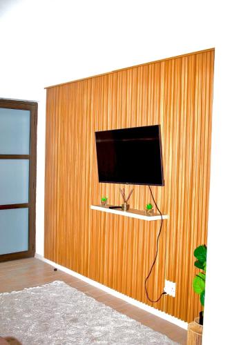 a wall with a flat screen tv on a wooden wall at Lighthaus44 in Ongwediva
