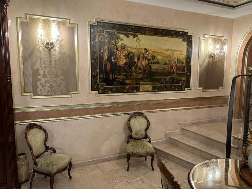 a room with two chairs and a painting on the wall at Villa Bijoux in Ploieşti