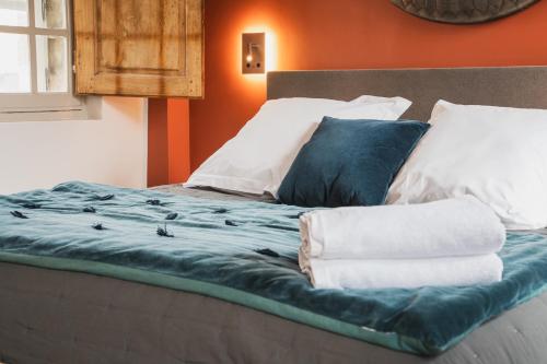 a bed with blue sheets and pillows on it at Les Jardins de Baracane in Avignon