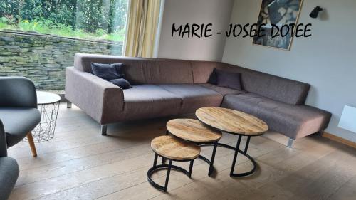a living room with a couch and two tables at Ardennature vakantiehuizen met privé-sauna in La Roche-en-Ardenne