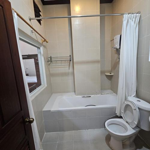 a bathroom with a tub and a toilet and a shower at Ali Xayathit Apartment & Hotel in Vientiane