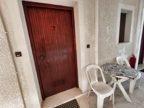 a red door in a room with two chairs and a table at Akrata Golden Beach House 2 in Aíyira