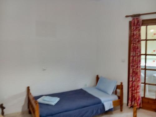 a bedroom with a blue bed and a window at Akrata Golden Beach House 2 in Aíyira