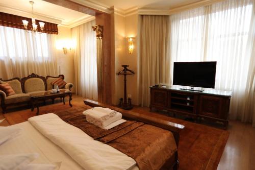 a bedroom with a bed and a flat screen tv at Villa Bijoux in Ploieşti