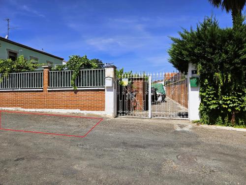 a fence with a gate in front of a house at Casa Azul donde se respira tranquilidad in Lardero
