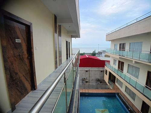a balcony of a building with a swimming pool at Elegant Beach Resort in Mandarmoni