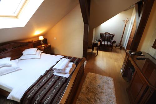 a bedroom with a bed with white sheets and a window at Villa Bijoux in Ploieşti