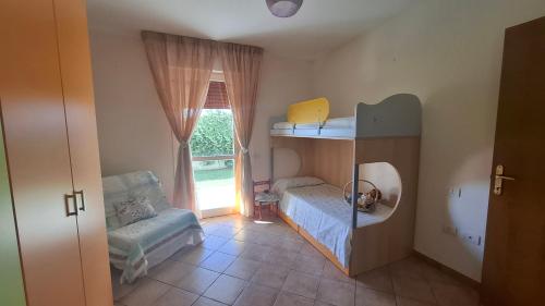 a small room with a bunk bed and a window at Casa nonna Elvia Elvia's Grandma home in Dolianova