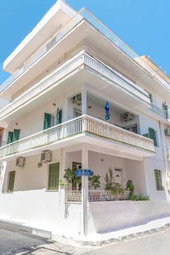 a white building with a balcony on a street at 5 steps from the sea in Kalamata
