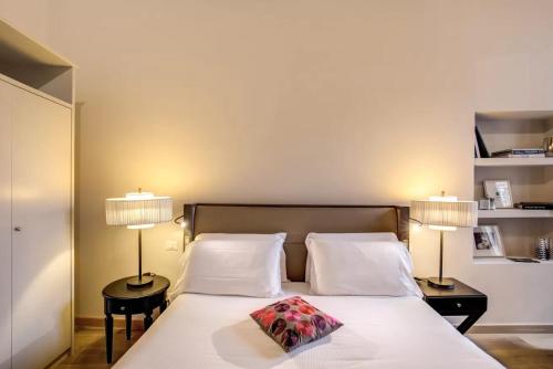 a bedroom with a bed with two lamps on it at Suites Giulia in Rome