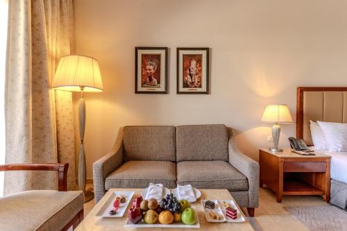 a hotel room with a couch and a table with food on it at Baron Palace Sahl Hasheesh in Hurghada