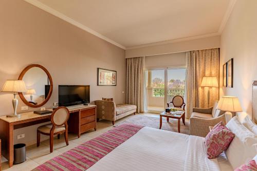 a hotel room with a bed and a mirror at Baron Palace Sahl Hasheesh in Hurghada