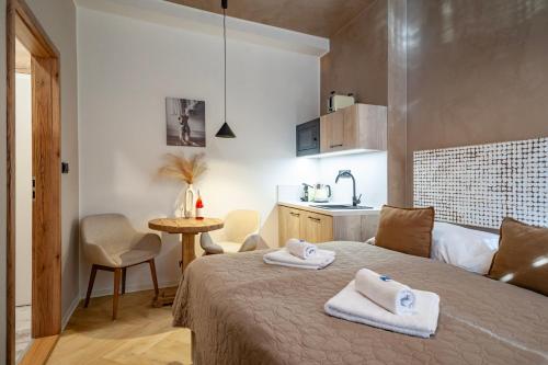 a bedroom with a bed with two towels on it at STING Boutique Apartments in Ostrava