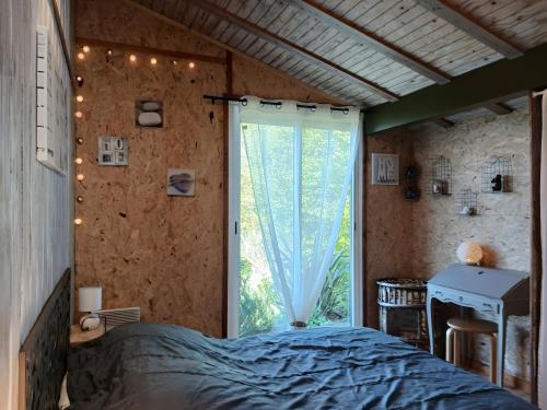 ein Schlafzimmer mit einem Bett und einem großen Fenster in der Unterkunft Chalet Sein Dans Parc Résidentiel in Pléneuf-Val-André