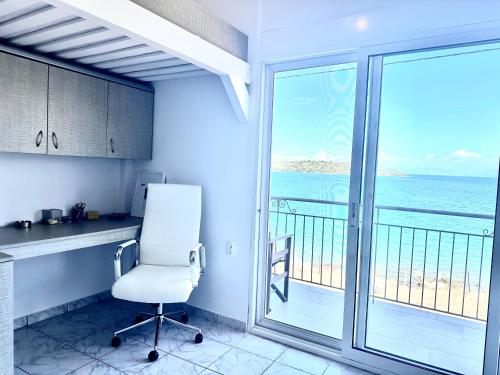 a white chair in a kitchen with a view of the ocean at ARTE MARE d'Irene in Spárton