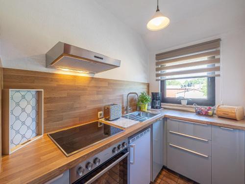 una cucina con lavello e fornello di La Casa Ferienwohnung Strandweg a Steinberg