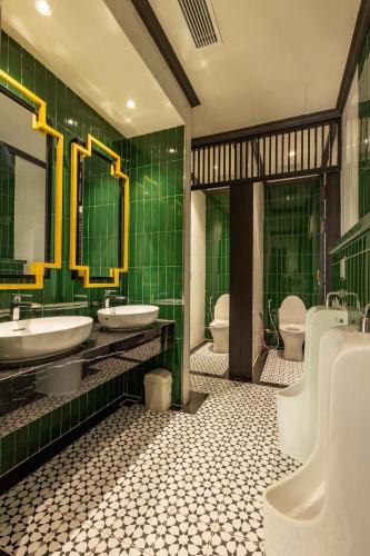 a green bathroom with two sinks and two toilets at Stella Marina Boutique Hotel in Phu Quoc