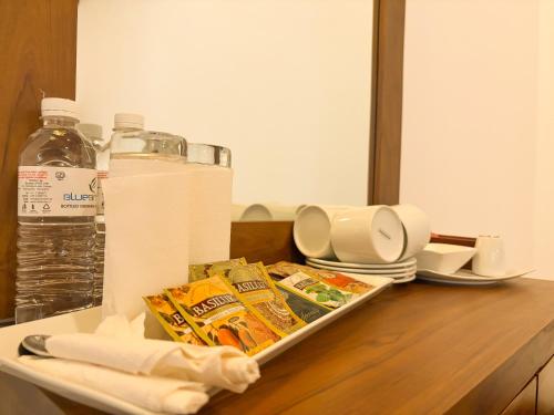a table with a tray of food and a bottle of water at Villa Blue Bird in Negombo