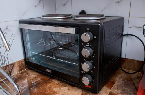 a black toaster oven sitting on top of a counter at Entebbe Serenity breeze apartments in Entebbe
