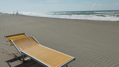 a beach chair sitting on the sand on the beach at Residence il Tombolo in Principina a Mare