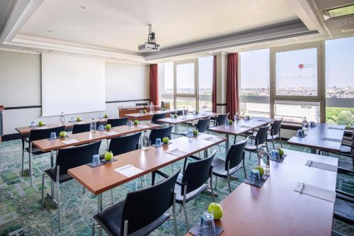 a classroom with tables and chairs and windows at Crowne Plaza Antwerpen by IHG in Antwerp
