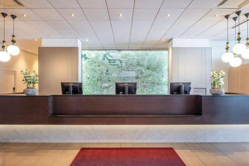 a lobby with a waiting area with a large window at Crowne Plaza Antwerpen by IHG in Antwerp