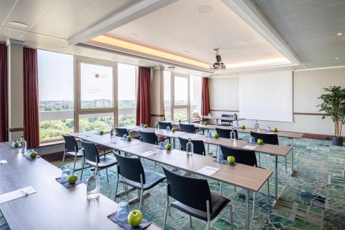 a conference room with tables and chairs and windows at Crowne Plaza Antwerpen by IHG in Antwerp