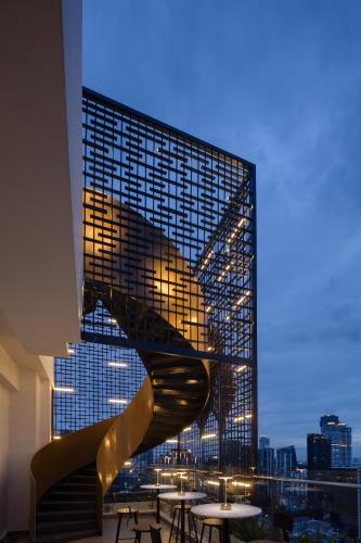 a staircase in a building with a view of a city at Bassac Signature Hotel & Residence in Phnom Penh