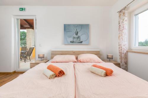 a bedroom with two beds with orange pillows on them at Villa Amalija in Krmenjak