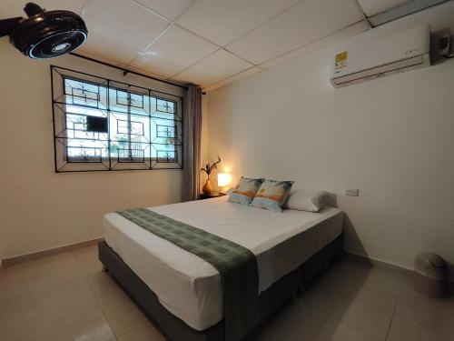 a bedroom with a large bed with a window at Bona Vida Casa in Ríohacha