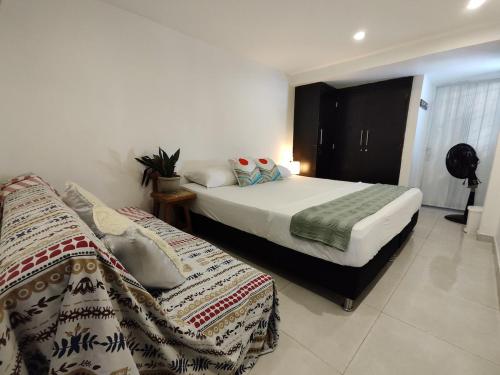 a bedroom with a bed and a couch at Bona Vida Casa in Ríohacha
