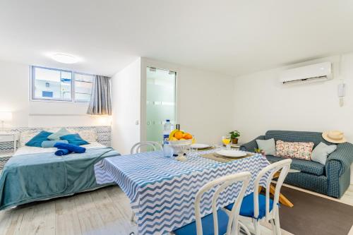 un salon avec une table, un lit et un canapé dans l'établissement Down Floor Studio in Centre City Puerto de la Cruz, à Puerto de la Cruz