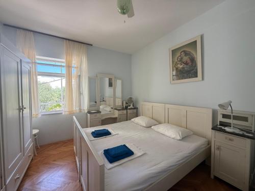 a bedroom with a bed with two blue towels on it at Hostel Guesthouse Mira in Omiš