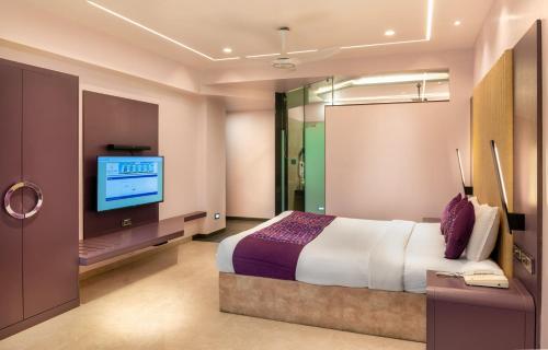 a bedroom with a bed and a flat screen tv at Hotel Royal Palace Jalgaon in Jālgaon