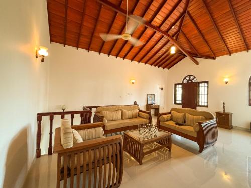a living room with couches and a table at Villa Blue Bird in Negombo
