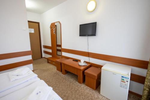 a hotel room with two beds and a tv at Hotel Hefaistos - Sovata in Sovata