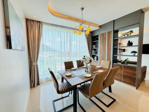 a dining room with a table and chairs and a window at 2BR 4Beds Luxury Condo Pool & Fitness in Phuket Town